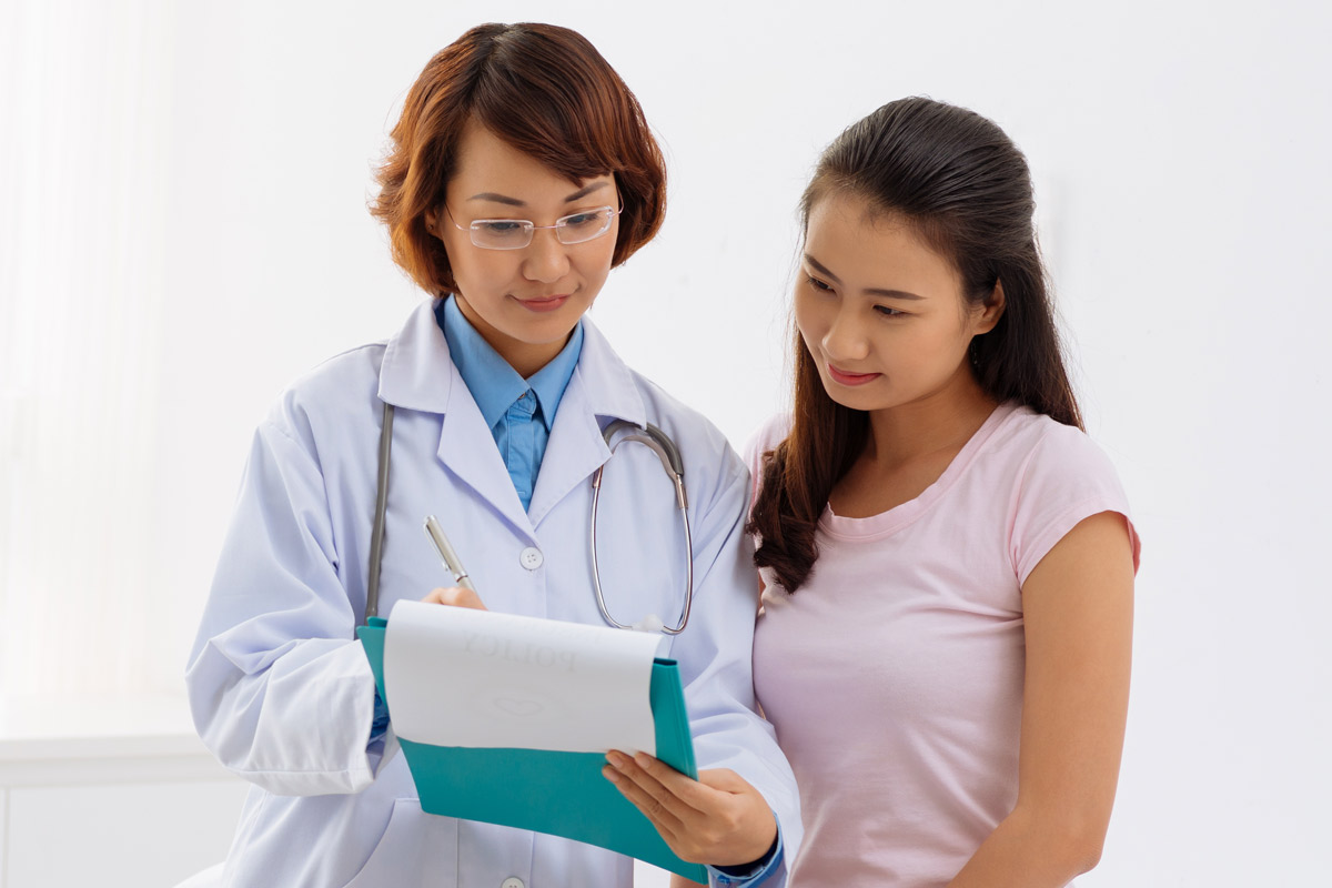 stock image of a physician and patient looking at something on a clipboard.