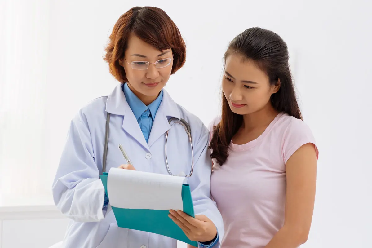 stock image of a physician and patient looking at something on a clipboard.