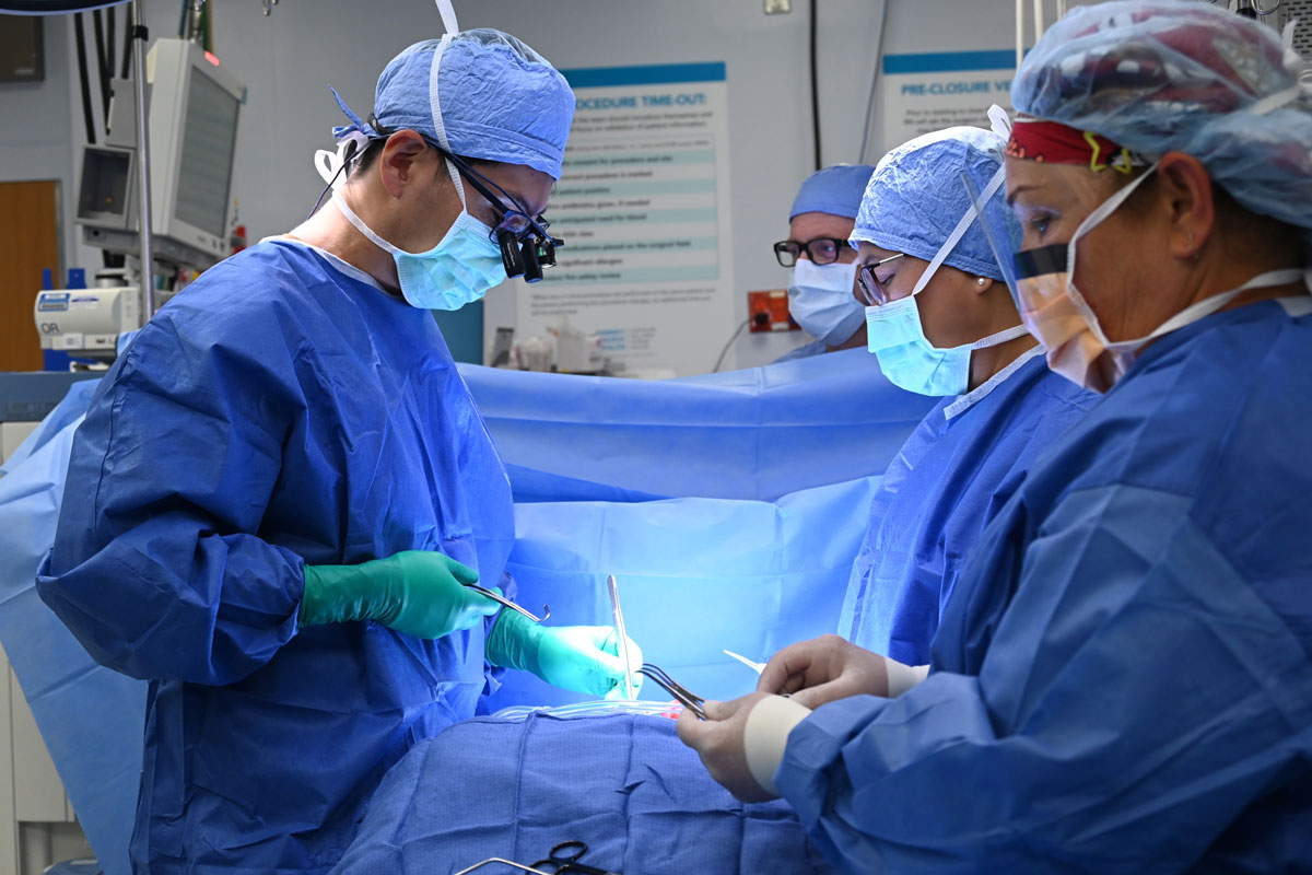 Surgeons perform heart surgery in an operating room.