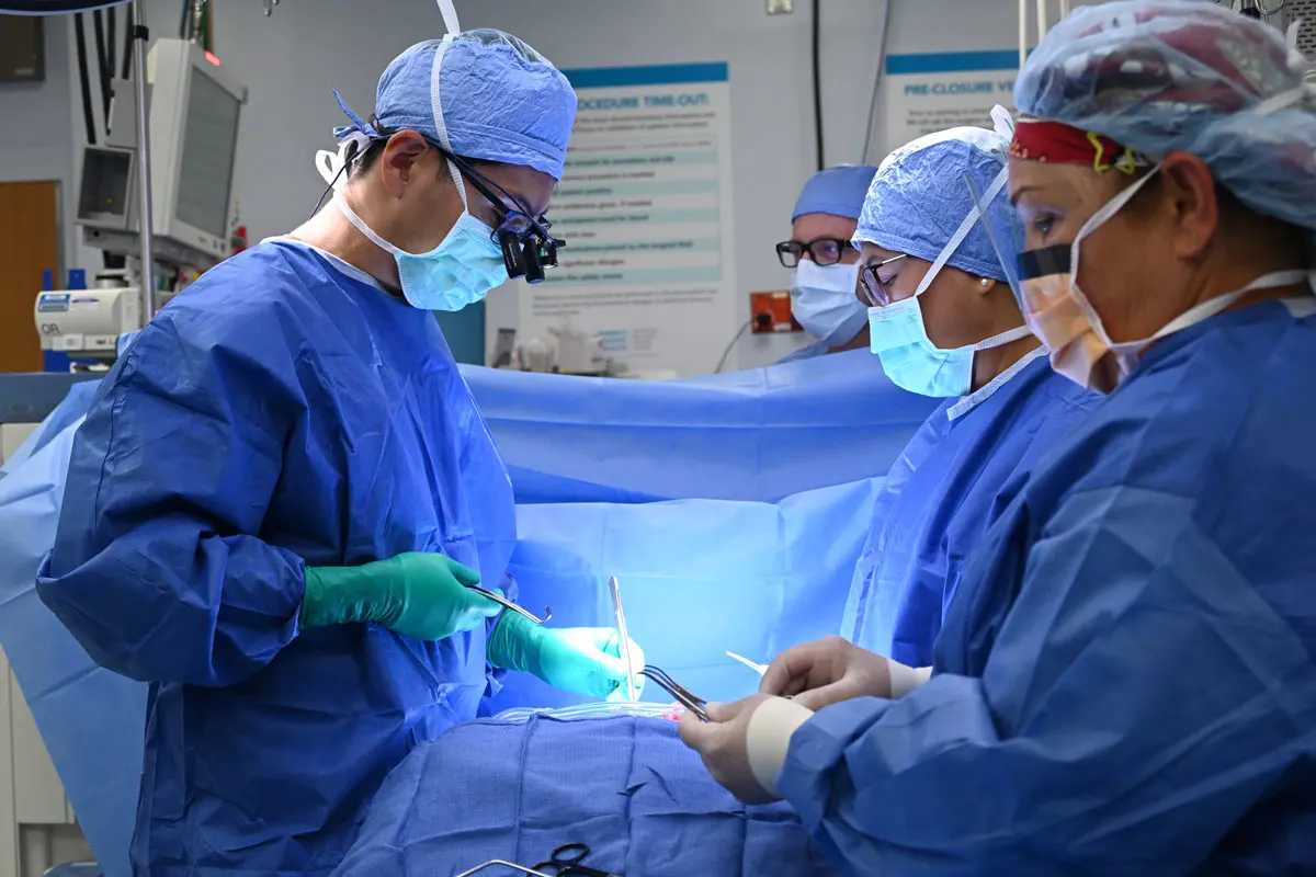 Surgeons perform heart surgery in an operating room.