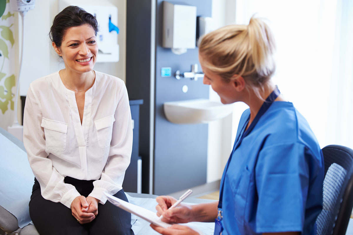 A woman talking to female doctor about her health history during an annual exam.