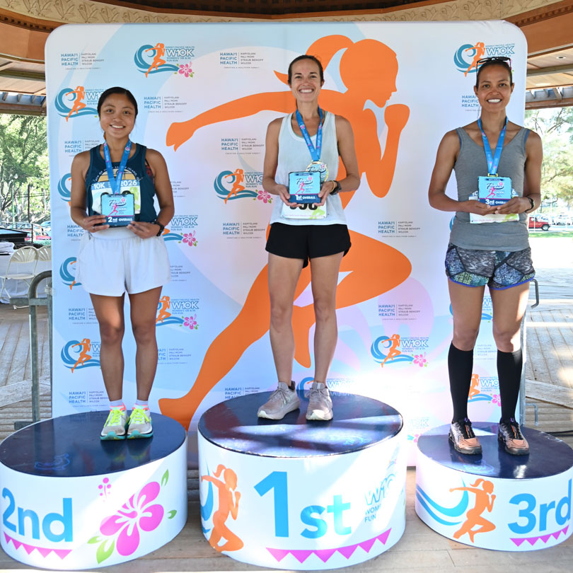 HPH Women's 10K top three finishers standing on winner podiums.