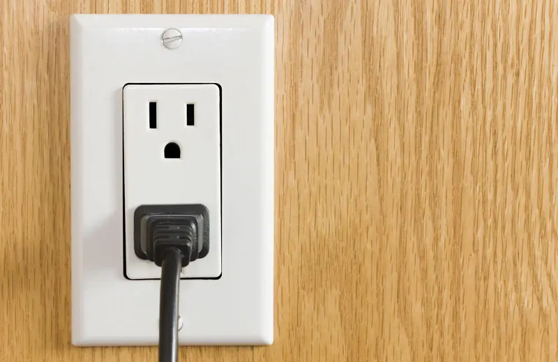 An uncovered open wall plug socket.