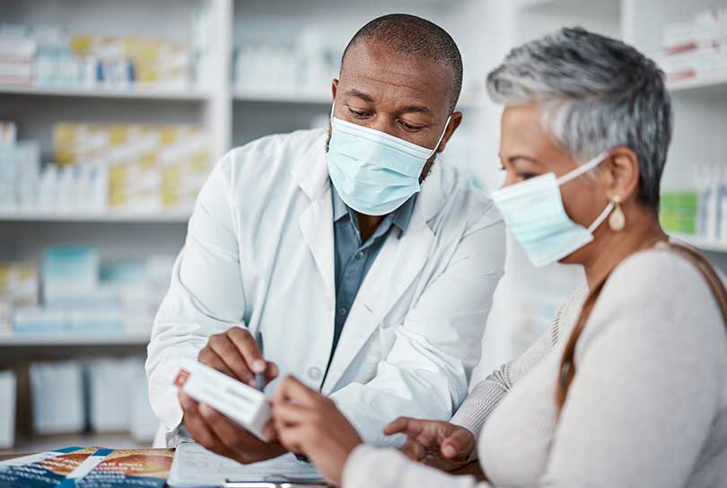 Stock photo of pharmacist consulting with patient