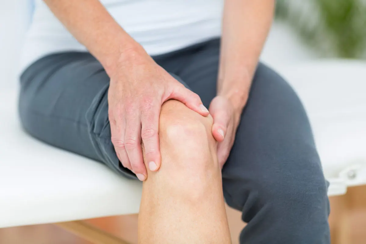 A patient clutching at sore knee.