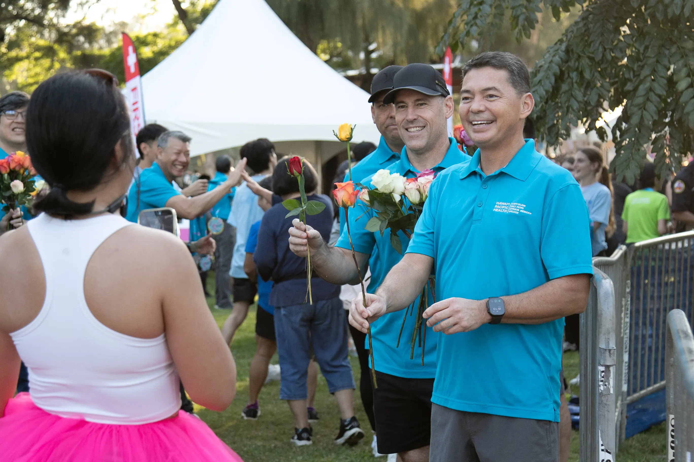 HPH employees handing out roses to the race finishers.