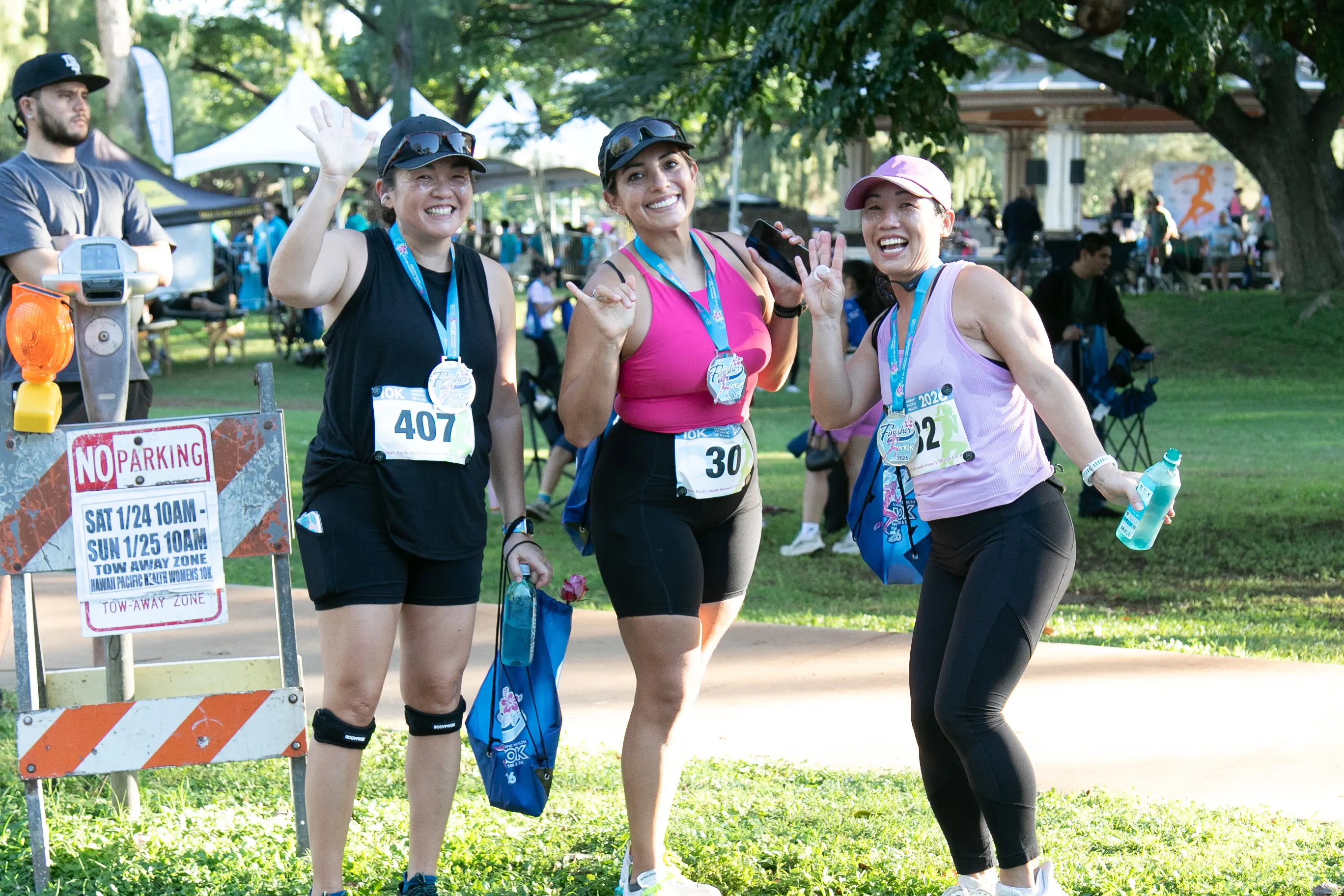 Three 10K participants smiling with their finisher medals.
