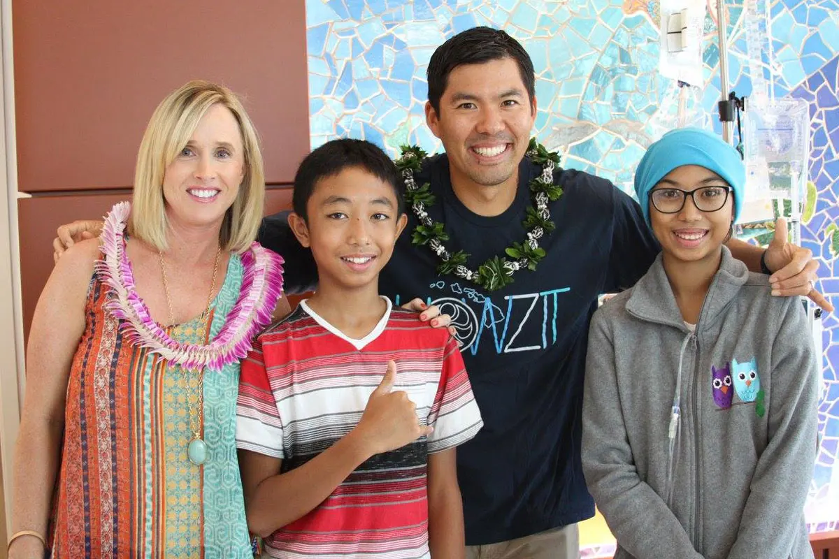 Husband and wife smiling with pediatric patients.