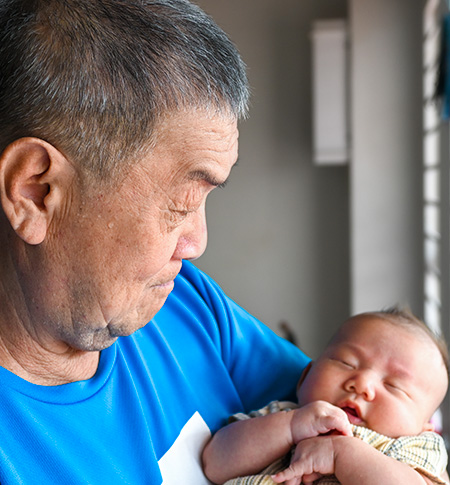 Grandpa holding sleeping infant