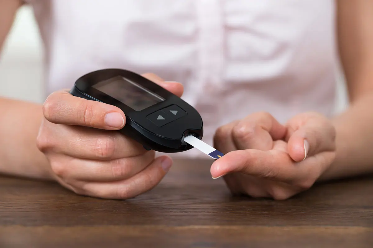 A patient testing her blood for diabetes.