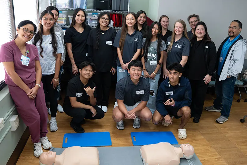 Group of students, instructors, staff, and providers smiling at the Pali Momi Career Fair.