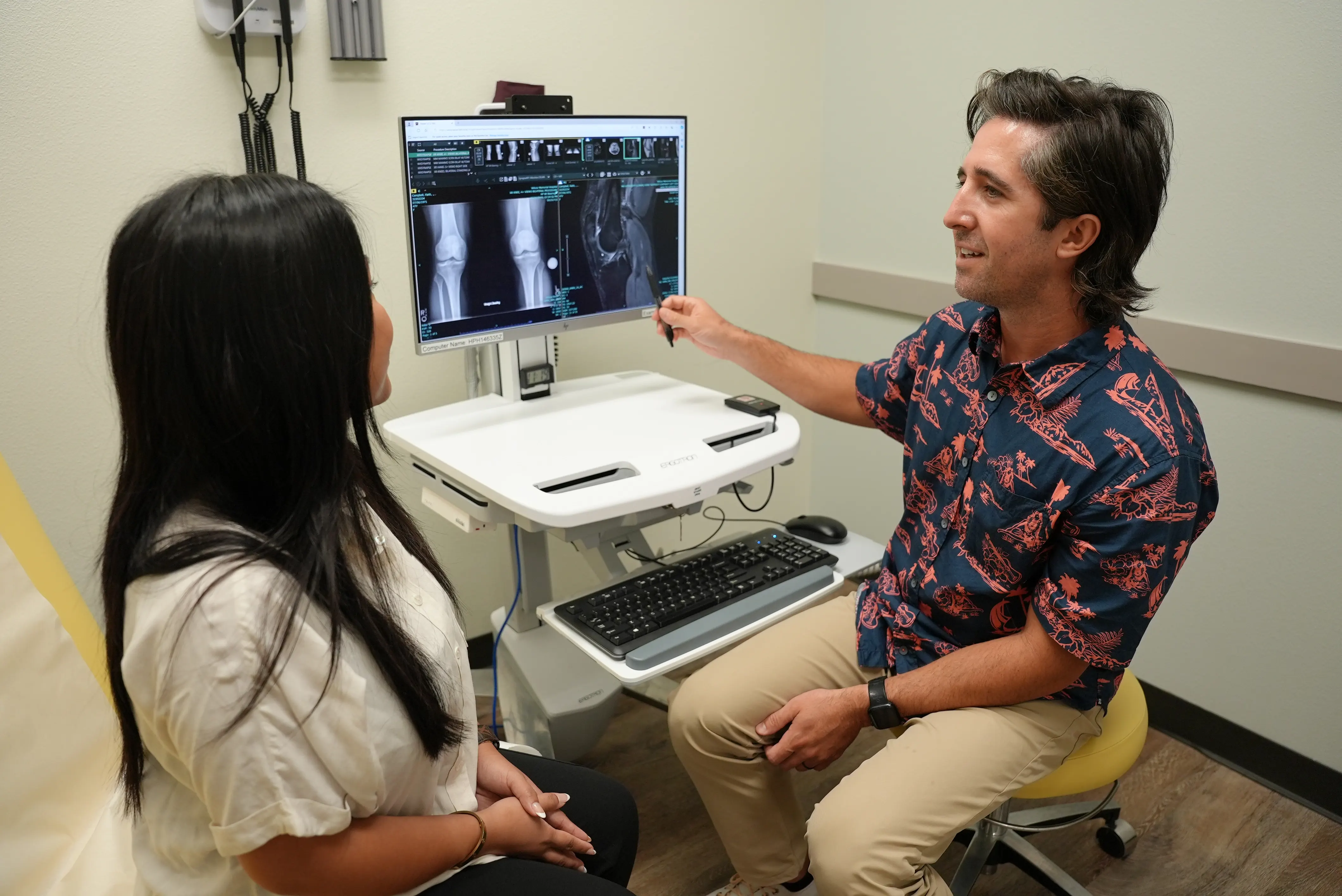 An orthopedic PA-C shows a patient her X-ray while seated in an exam room at Kauai Medical Clinic – Kapa‘a.