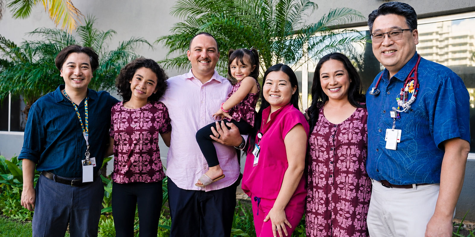 Smiling group including a young patient, her family and providers.