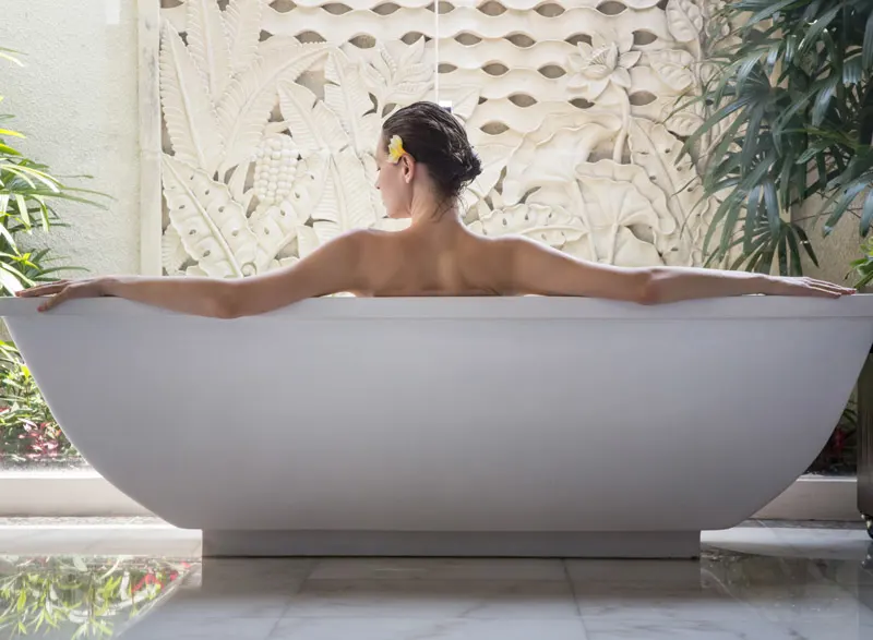A woman's shoulders sit above a white tub.