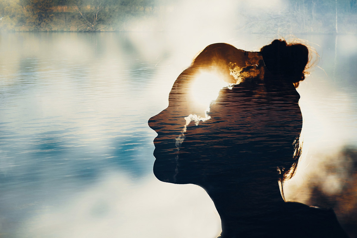 A woman looking into the distance is super imposed with the sun.