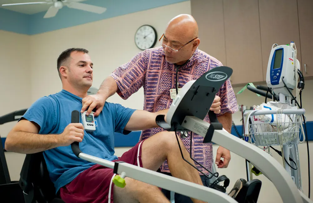 a cardiologist monitors a patient exercising on a stationary bike during a session at the Wilcox Cardiac Rehab progam.