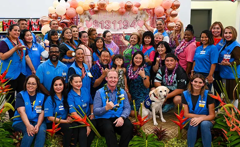 Group of walmart employees celebrating their fundraising efforts with Kapiolani's CMN Champion Kalley-mae and her family.